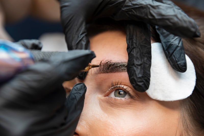 Women getting brow microblading